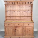 A pine dresser with a plate rack above, cupboards below,