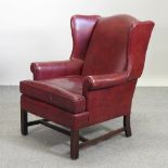 A Georgian style red leather upholstered wing armchair,
