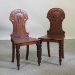 A pair of Victorian carved mahogany shield back hall chairs