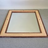 A large rattan framed wall mirror, with brass stud decoration,