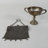An early 20th century silver mesh purse, together with a twin handle cup,