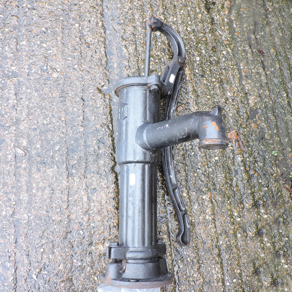 A black painted cast iron garden pump,