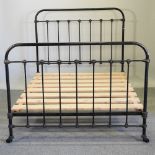 A Victorian black painted iron bedstead, with slatted wooden base,