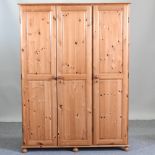 A modern pine triple wardrobe,