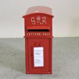 A red painted metal GPO style postbox,