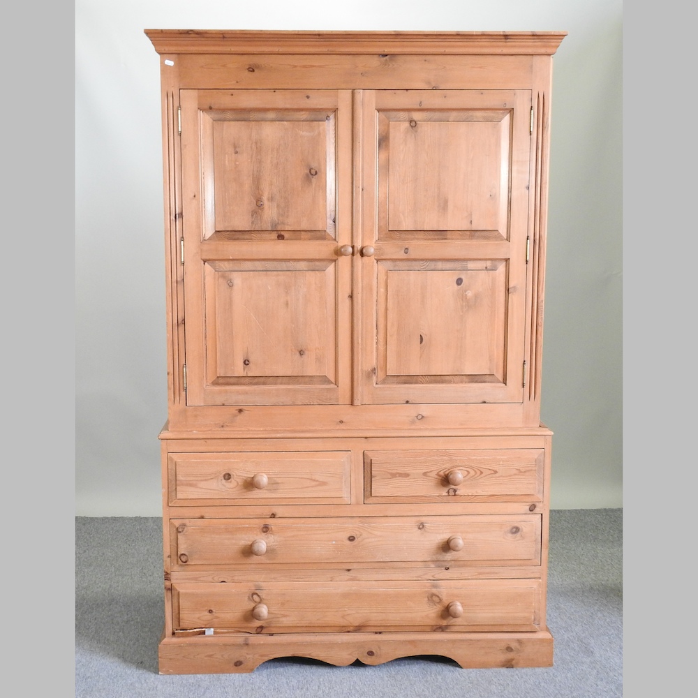 A pine wardrobe, with drawers below,