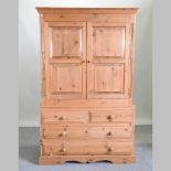 A pine wardrobe, with drawers below,