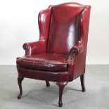 A red upholstered wing armchair,
