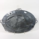 An early 20th century pewter plaque, of oval shape, with entwined twig handles,