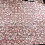 A large modern Indian woollen carpet, with all over floral design, on a red ground,