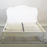 A modern white painted double bedstead,