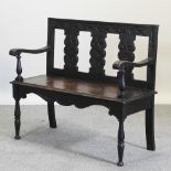 A late 19th century carved oak bench,