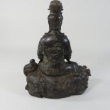 A Chinese bronze figure group of Guanyin, seated on a dog of fo,