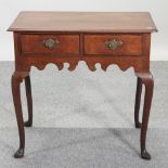 An 18th century oak lowboy, containing two drawers, on cabriole legs,