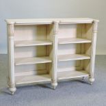 A William IV style cream painted open bookcase,