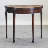 A George III half round mahogany tea table, on square tapered legs,