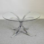 A chrome coffee table with a circular glass top,