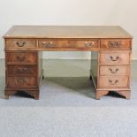 A reproduction mahogany pedestal desk, with a brown leather inset top,