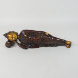 A reproduction Eastern bronze figure of a deity, lying with his head on a pillow,