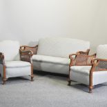 A 1920's single cane bergere three piece suite, comprising a sofa,