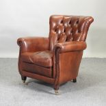 A 1920's style brown leather button back armchair