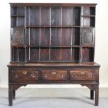 A 19th century stained pine dresser, with plate rack, containing three short drawers,