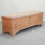 A 19th century pine blanket box, with an upholstered seat,