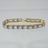 A 18 carat gold aquamarine link bracelet, set with eighteen octagonal cut stones,