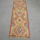 A kelim runner, with five central diamond pattern, on a cream ground,