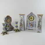 A faience pottery clock garniture, together with another smaller,