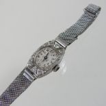 A platinum and diamond set ladies cocktail watch, the oval dial, with a diamond set bezel,