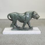 An African carved stone sculpture of a lion, on a white marble base, signed Jonah Runyanga,