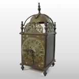 A brass cased lantern clock, the case surmounted by a bell, the movement striking on a bell,