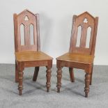 A pair of Victorian Gothic light oak hall chairs