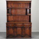 A modern oak dresser, with plate rack, on a plinth base,