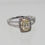 A 14 carat gold, diamond halo ring, set with a yellow diamond, within a diamond surround,