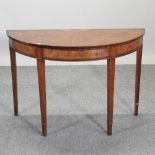 A George III style walnut and marquetry half round side table, with a radially veneered top,