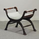 An Edwardian mahogany x frame stool, on paw feet,