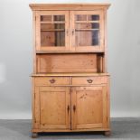 An antique pine dresser with a glazed upper section,