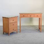 A modern light oak bedside chest, together with a matching writing table,