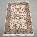A Persian woollen rug, with all over foliate designs, on a cream field,