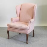A Georgian style peach upholstered wing armchair,