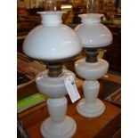 A matched pair of antique milk glass oil lamps with brass burners and mushroom shades.