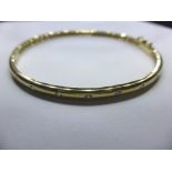 A 9ct gold and diamond bangle,