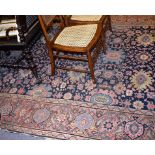 An antique Turkish rug with dark blue floral field and Herati border, worn.