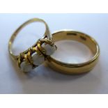 A 14ct gold wedding ring and a 10ct gold opal ring (one opal cracked). (2),