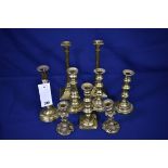 A small collection of antique brass candlesticks of varying sizes forms and dates, to include four