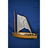 A late 19th/early 20th century clinker built model dingy the mast with damage, the main hull