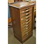 A Globe Wernicke filing cabinet with nine pull out trays and a pull up concertina front with brass