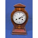 An Edwardian inlaid mahogany mantel clock the ivory enamel Roman dial within a vase shaped case with